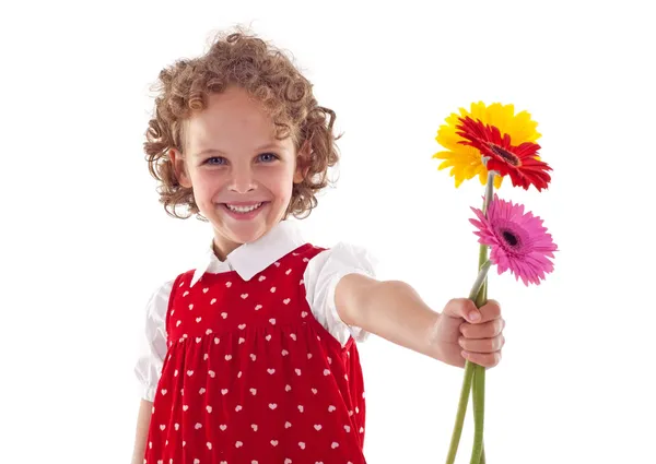 Посміхаючись маленька дівчинка дарує квіти на день матері — стокове фото