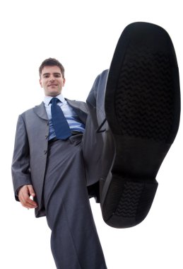 Smiling business man steping on something clipart