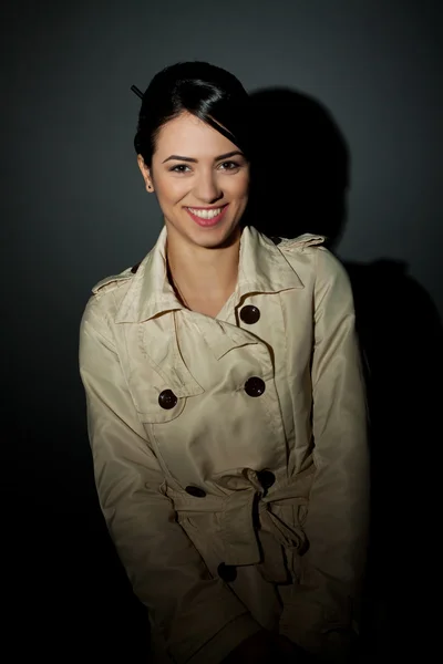 Woman wearing a trench coat and smiling — Stock Photo, Image