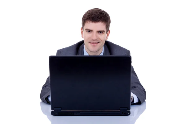Executive in suit behind desk with laptop Stock Image