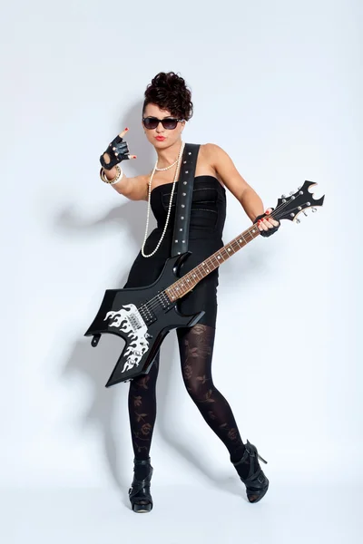 Женщина в черном платье делает рок-знак — стоковое фото