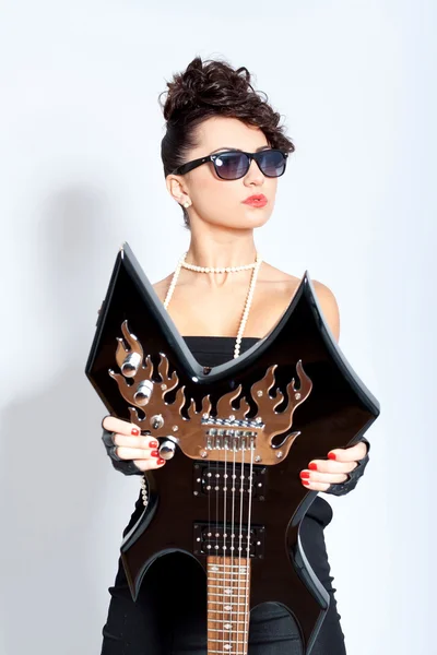 Mujer de moda con gafas de sol sosteniendo una guitarra eléctrica —  Fotos de Stock
