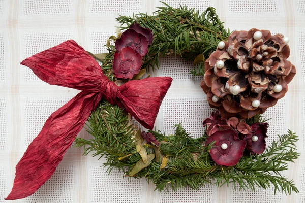 kurumuş doğa ürünleri ve kırmızı kurdele yapılmış el yapımı Noel çelenk.