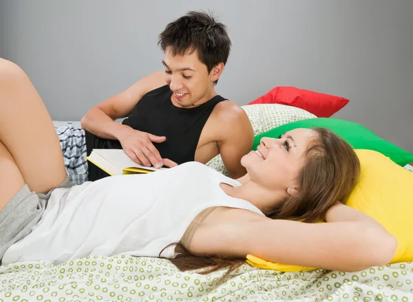 Gelukkige paar met boek in bed — Stockfoto
