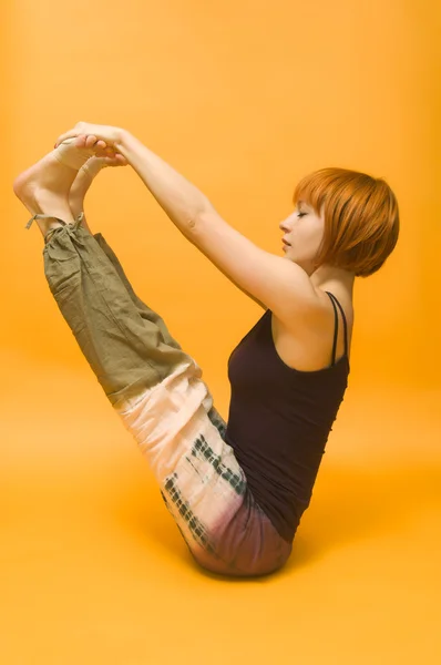 Red girl performing yoga asana — Stock Photo, Image