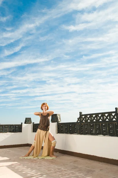 在背景中执行瑜伽舞蹈户外与蓝蓝的天空和云的美丽年轻舞者 — 图库照片
