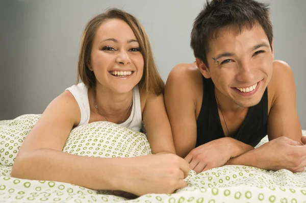 Cheerful couple in bed — Stock Photo, Image