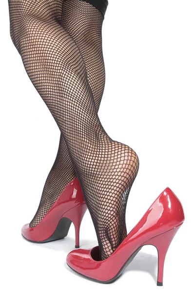Krásná žena nohy punčocháče s červenými podpatky nad bílé backgro — Stock fotografie