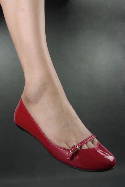 Piękna kobieta nogi czerwone obcasy ponad szary — Zdjęcie stockowe