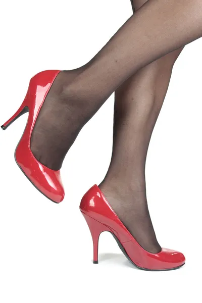 Vacker kvinna ben tights med röda klackar över vita backgro — Stockfoto