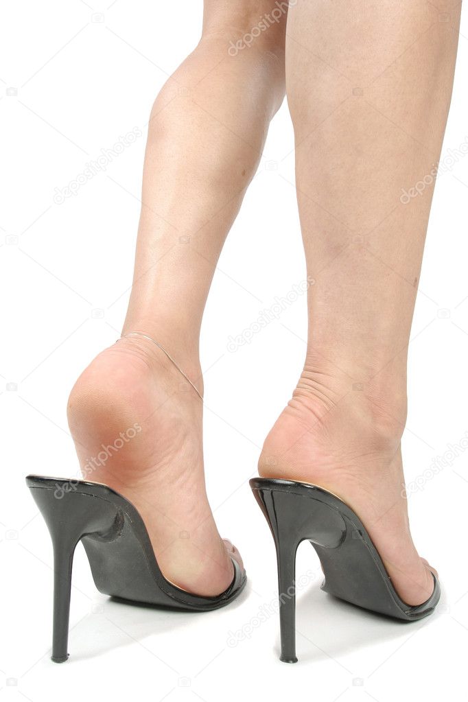 Beautiful woman legs with black heel shoes over white background