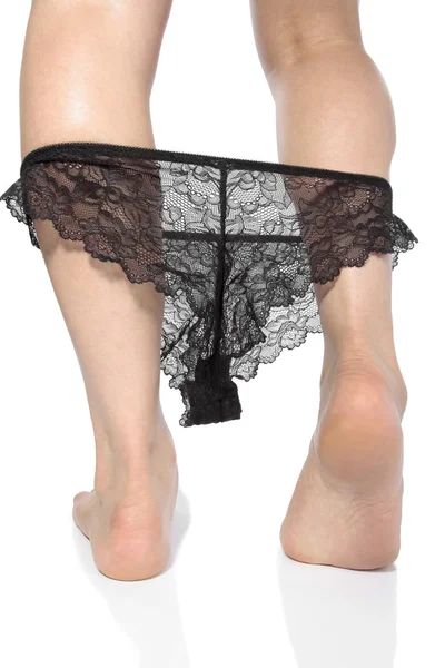 Сексуальные ноги в черном нижнем белье раздеваются на белом фоне — стоковое фото