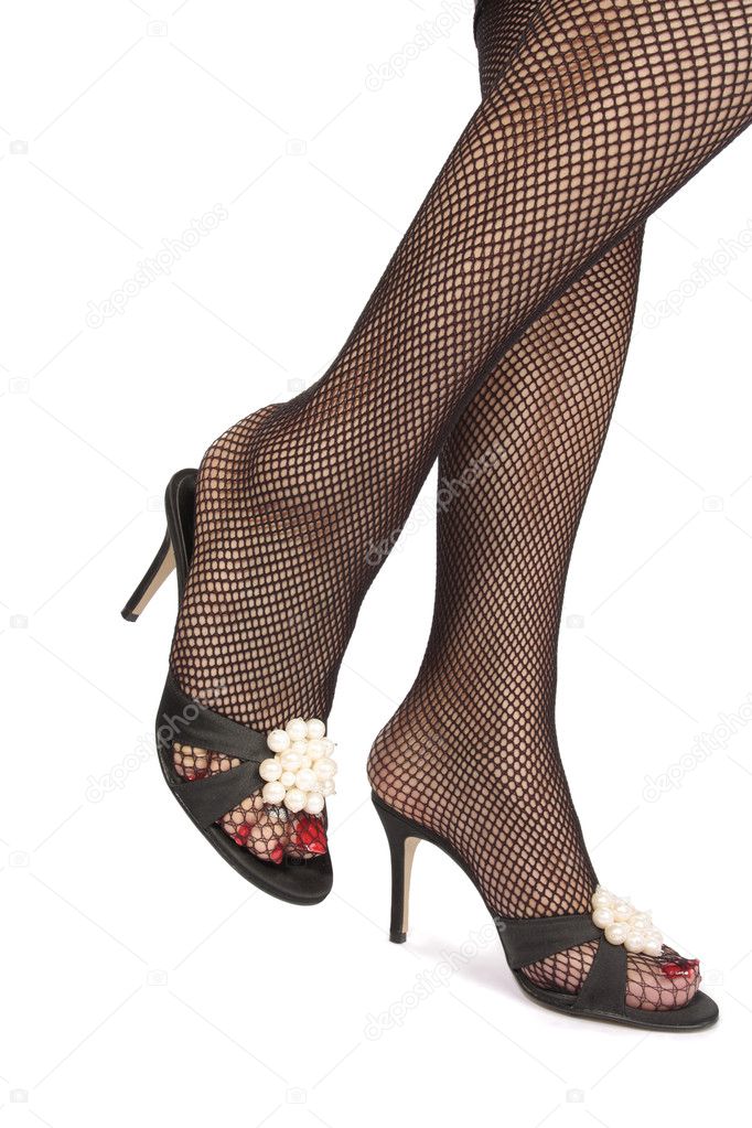 Woman legs with fishnet stockings and heels over white backg