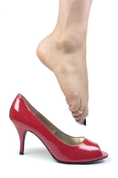 Frauenfüße ziehen rote Schuhe an — Stockfoto