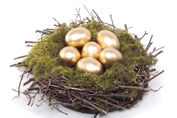 Uova d'oro nel nido d'uccello su bianco — Foto Stock