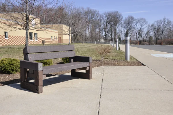 Empty bench by a school — Stock Photo, Image
