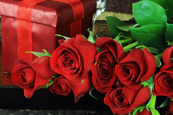 Красная роза и подарок — стоковое фото