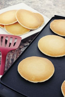 Preparing fresh pancakes on a non-stick griddle. clipart
