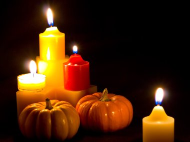 Mini Pumpkins and Candles with a Black Cloth Background clipart