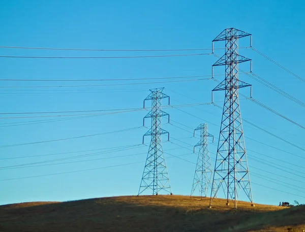 在小山在一片蓝天之前各种电气电力线 — 图库照片