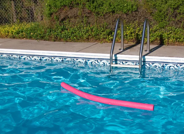 Piscina Azul. Escada, e brinquedo de piscina rosa em plena luz do sol — Fotografia de Stock