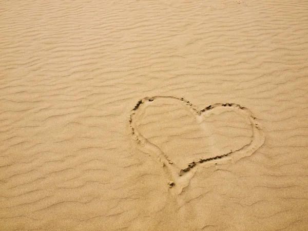 Szív, egy napsütéses napon a homokba — Stock Fotó