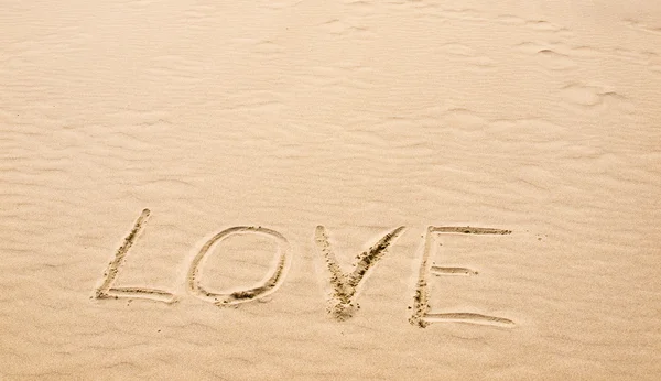 Liefde geschreven in het zand op een zonnige dag Stockafbeelding