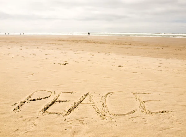 "Fred er skrevet i sanden på en solskinnsdag". – stockfoto