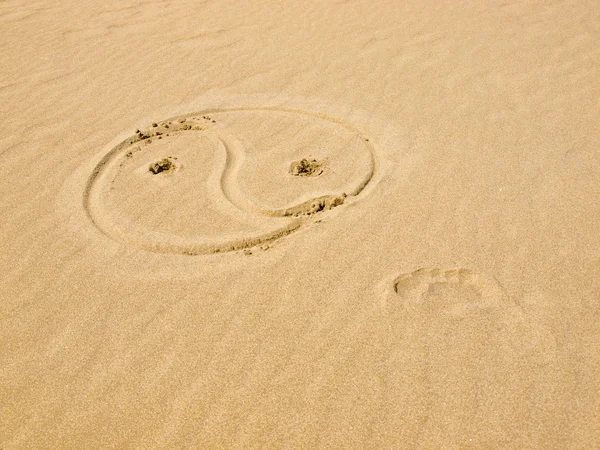 Yin και yang σύμβολο γραμμένο στην άμμο σε μια ηλιόλουστη ημέρα — Φωτογραφία Αρχείου