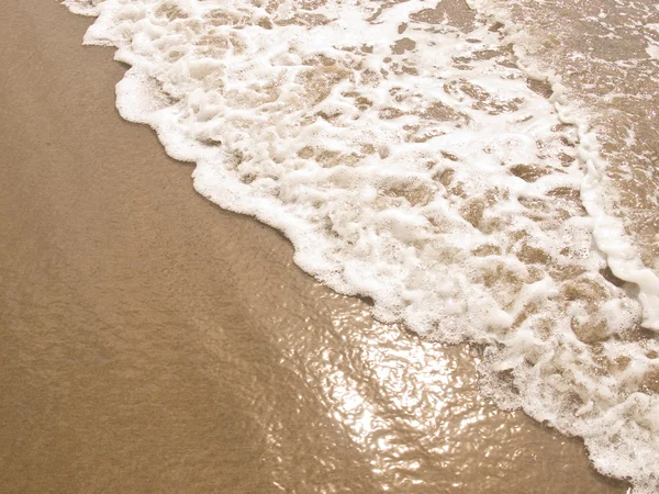 Schäumende Meeresküste an einem sonnigen Strand — Stockfoto