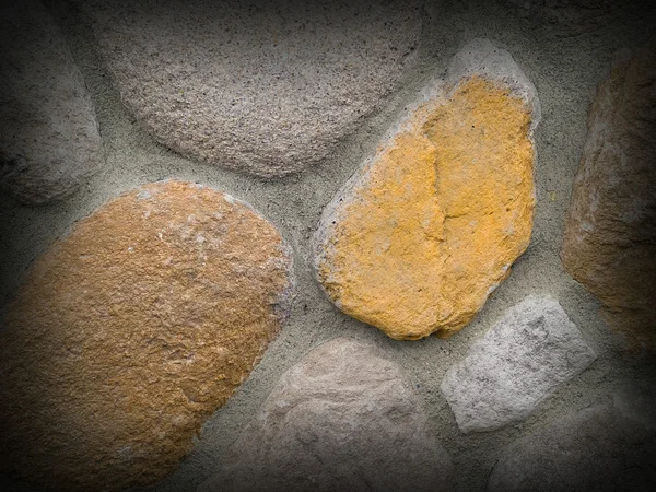 Parede de rocha e concreto com grandes pedras arredondadas — Fotografia de Stock