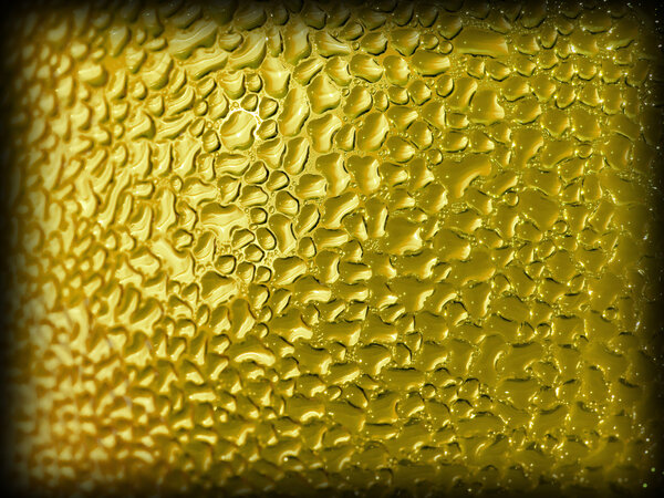 Water droplets formed from condensation inside a gold bottle with dark edge border