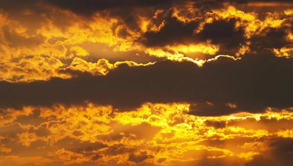 Goldener Himmel mit dicken Wolken bei Sonnenaufgang — Stockfoto