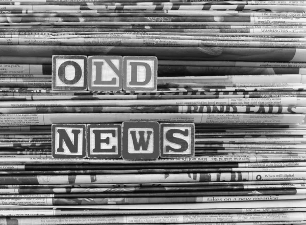 Anciens journaux empilés et "Nouvelles anciennes" est écrit en lettres moulées — Photo