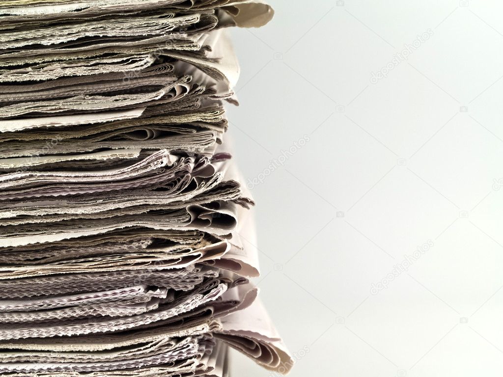 Old newspapers stacked from the top to bottom of the frame isolated on whit