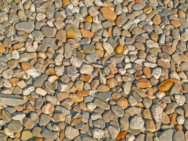 Fundo de pequenas pedras redondas com luz solar completa — Fotografia de Stock