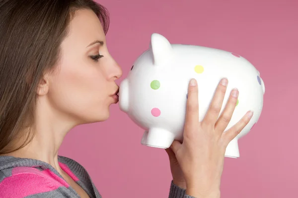 漂亮的女孩接吻猪存钱罐 — 图库照片