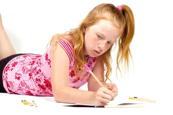 Ruiva menina está fazendo seu dever de casa — Fotografia de Stock