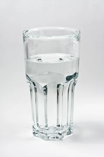 Стеклянная вода на сером фоне — стоковое фото