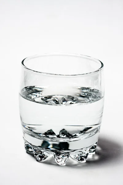 Vidro whith água sobre fundo cinza — Fotografia de Stock