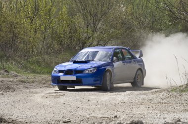 Blue racing rally car on gravel road clipart