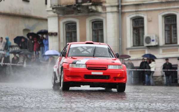 Красный раллийный гоночный автомобиль на мокрой дороге — стоковое фото