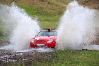 Red rally car and water splash clipart