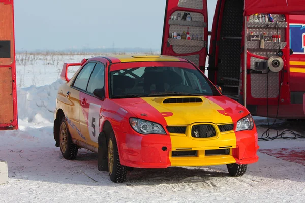 Красный и желтый раллийный автомобиль на снегу — стоковое фото