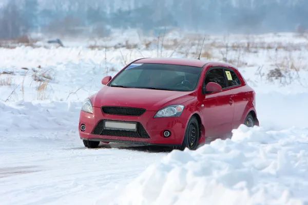 Κόκκινο αγωνιστικό αυτοκίνητο στην πίστα αγώνων του χειμώνα — Φωτογραφία Αρχείου