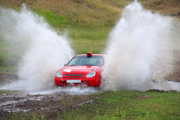Red rally car and water splash — Stock Photo, Image
