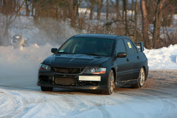 Svart rallybil på vintern tävlingsbanan Royaltyfria Stockfoton