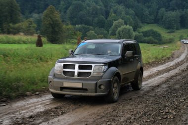 Black car on dirt road clipart