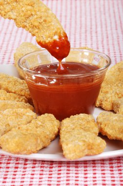 Dipping chicken finger in BBQ sauce clipart
