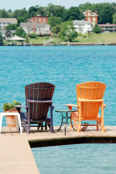 Braune und orangefarbene Adirondack-Stühle auf einem Dock — Stockfoto